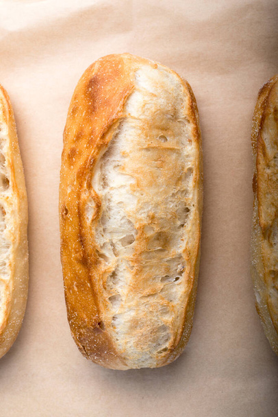 Французький хліб котиться рядами на випічці паперу.. - Фото, зображення