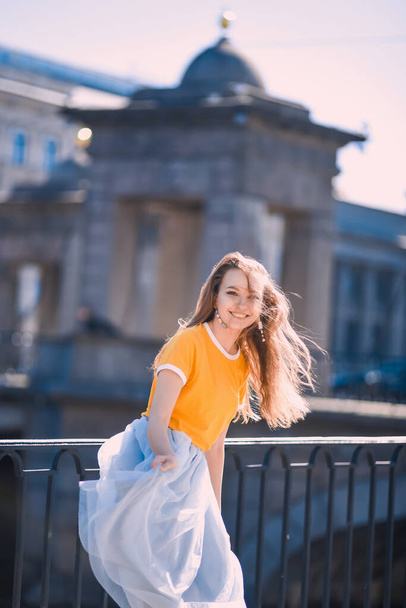 Nahaufnahme Porträt eines jungen Mädchens Hipster schöne Blondine mit blauem Rock lachen und posieren vor dem Hintergrund der Stadt St. Petersburg - Foto, Bild