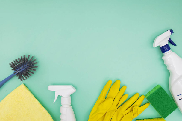 Cleaning tools and supplies on green background, top view. - Foto, imagen
