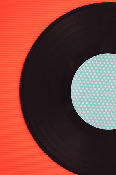 Zwarte muziek vinyl op een rode achtergrond bovenaanzicht - Foto, afbeelding