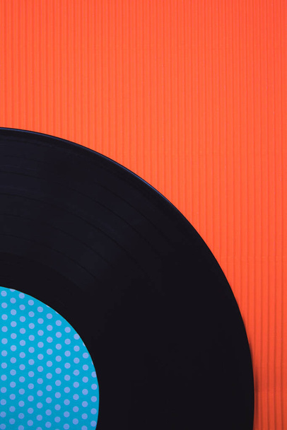 Zwarte muziek vinyl op een rode achtergrond bovenaanzicht - Foto, afbeelding