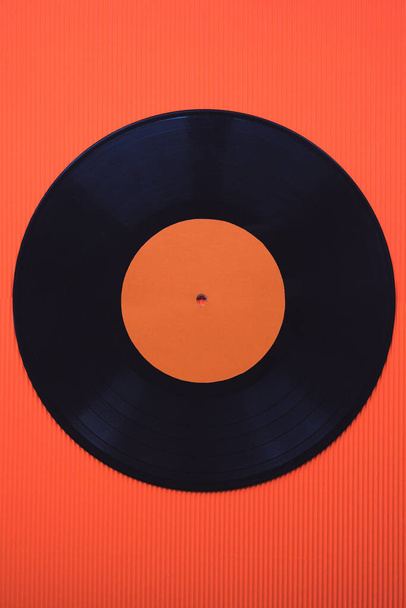 Vinyle de musique noir sur fond rouge vue du dessus
 - Photo, image
