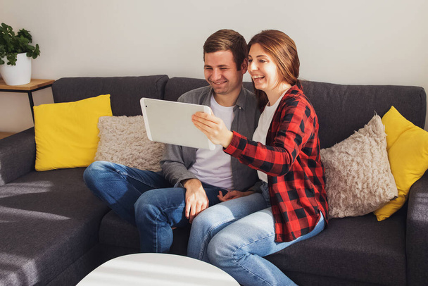 Young smiling couple making video call using digital tablet - Φωτογραφία, εικόνα