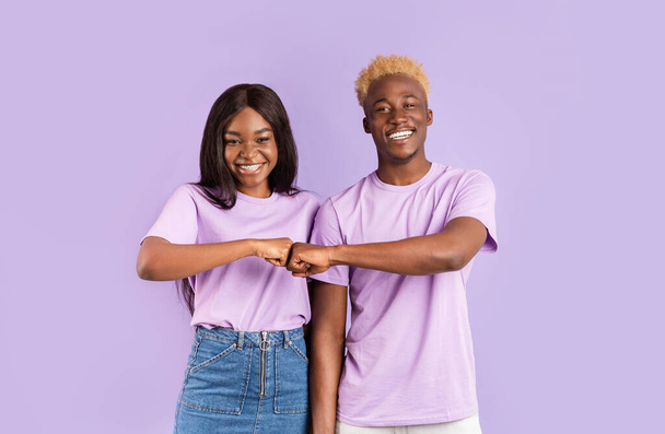 beau noir guy et fille faire poing bosse geste sur violet fond
 - Photo, image