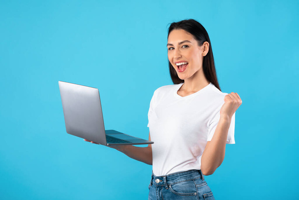 Excited female employee feeling ecstatic holding laptop - Foto, Imagen