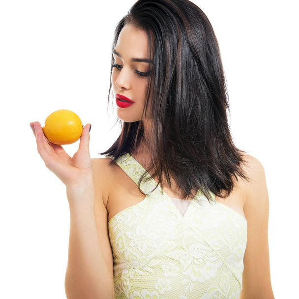 Excited beautiful girl holding lemon and posing in studio over white background. - Foto, imagen