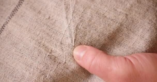 Hands of caucasian man : white threads, the needle on the background of linen fabric. the concept of embroidery and needlework. Copy space. Free space for text. - Footage, Video