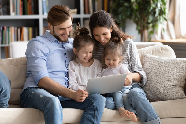 Famille heureuse avec des enfants utilisant un ordinateur portable à la maison
 - Photo, image