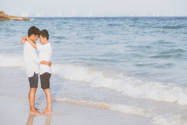 Homoszexuális portré fiatal ázsiai pár álló ölelés együtt strandon nyáron, ázsiai meleg megy turizmus szabadidős és pihenjen romantikus és boldog nyaralás a tengeren, Lgbt jogi koncepció. - Fotó, kép
