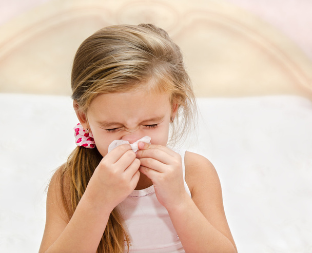 Little girl blowing her nose in a great effort - Fotó, kép