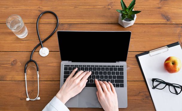 Blog e consulta médica online. Mãos femininas em um casaco branco no computador portátil
 - Foto, Imagem