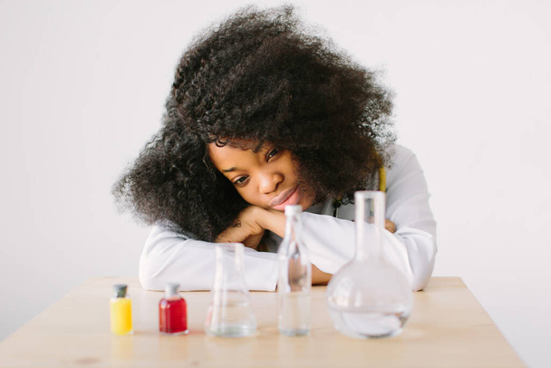 Laboratory work. Portrait of a young beautiful African American girl researcher chemistry student carrying out research in a chemistry lab. - Photo, image