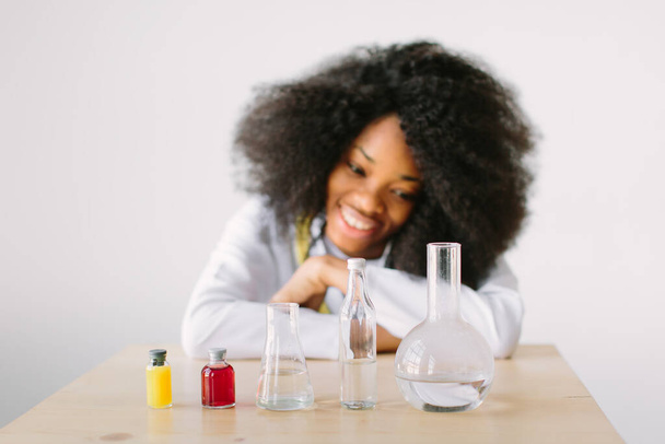 Laboratory scientist, chemist or pharmacist at work in a laboratory. Portrait of a young beautiful African American girl researcher chemistry student carrying out research in a chemistry lab. - Fotografie, Obrázek