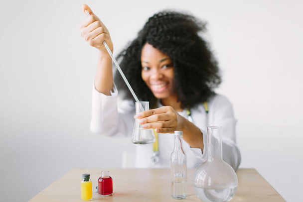 Young beautiful African American girl female with glass equipment in the lab Researcher researching in the laboratory - Фото, зображення