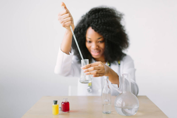 Young beautiful African American girl female with glass equipment in the lab Researcher researching in the laboratory - Photo, image