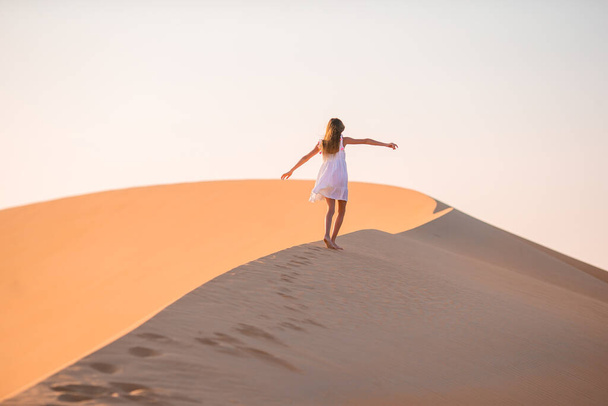 Κορίτσι ανάμεσα σε αμμόλοφους στην έρημο Rub al-Khali στα Ηνωμένα Αραβικά Εμιράτα - Φωτογραφία, εικόνα