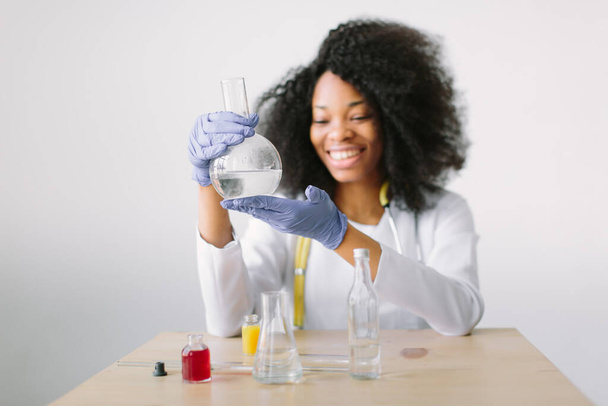 Young beautiful African American girl female with glass equipment in the lab Researcher researching in the laboratory - Fotoğraf, Görsel