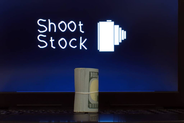 Geschäftsdiagramm auf dem Laptop-Bildschirm - Text auf dem Laptop-Bildschirm schießen Aktien und Dollar auf der Tastatur - Foto, Bild