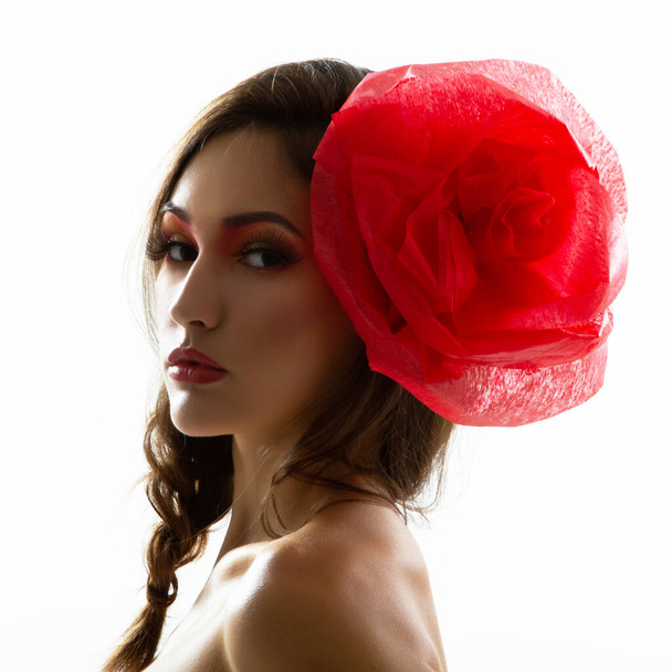 Vintage portrait of fashion glamour girl with red flower in her hair, studio shot. Young woman with beautiful make-up  - Zdjęcie, obraz