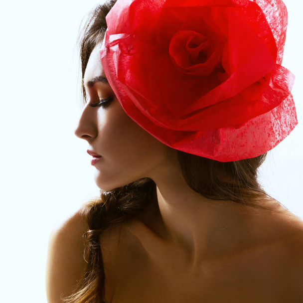 Vintage portrait of fashion glamour girl with red flower in her hair, studio shot. Young woman with beautiful make-up  - Foto, imagen