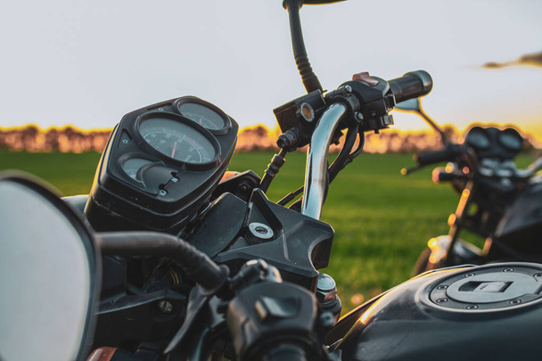 duas motocicletas pretas em um fundo de pôr do sol em cores quentes
 - Foto, Imagem