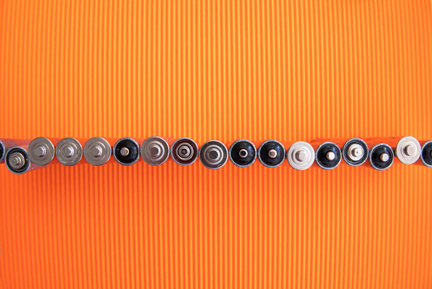 Срібні батареї на помаранчевому фоні
 - Фото, зображення