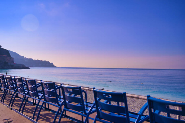 Cadeiras azuis ao longo da Promenade des Anglais no Mar Mediterrâneo em Nice, França ao longo da Riviera Francesa
. - Foto, Imagem