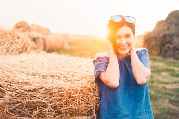 Beatiful woman posing at background of haystacks - Photo, image