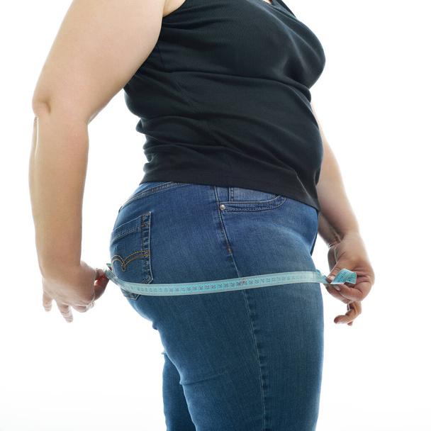 Надмірна вага нещасної молодої жінки, що вимірює стегна, ізольовані на білому тлі. Жінка з мірною стрічкою розміром Xl
 - Фото, зображення