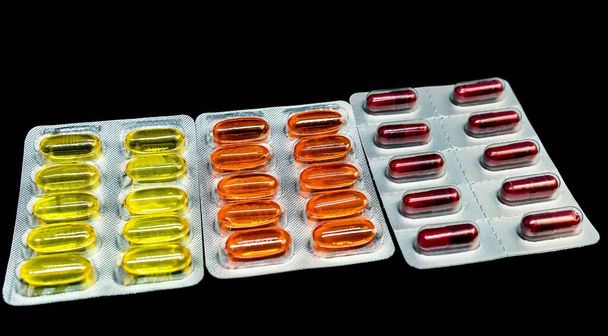 Pile of pills and vitamins in blister packs on dark background with copy space. Medical pharmacy concept. Selective focus. - Photo, Image