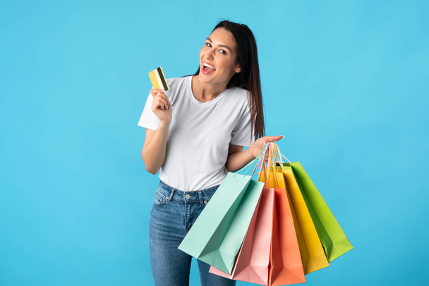Cheerful woman with shopping bags and plastic card - Foto, Bild