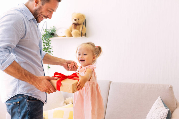Aufgeregt Mädchen hält ihr Geschenk mit Papa - Foto, Bild