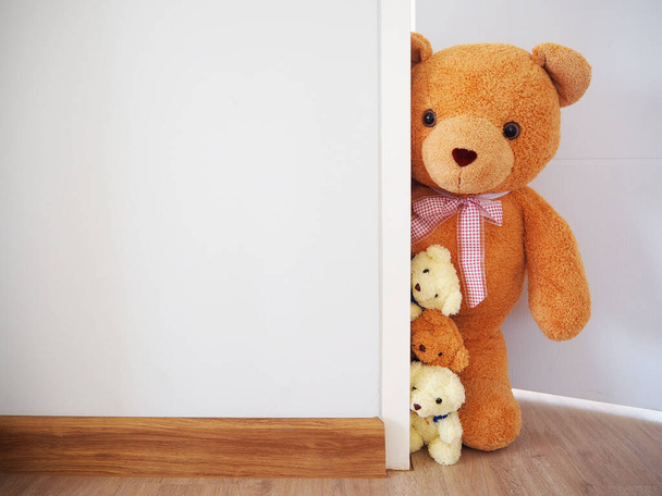 Hintergrund für Kinder. Die Teddybärenfamilie steht hinter der Mauer. - Foto, Bild