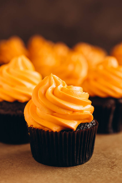 Stylish Festive cupcake and pumpkin on a dark background. sweets for the celebration of Halloween - Foto, afbeelding