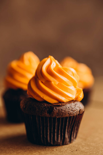 Stylish Festive cupcake and pumpkin on a dark background. sweets for the celebration of Halloween - Foto, afbeelding
