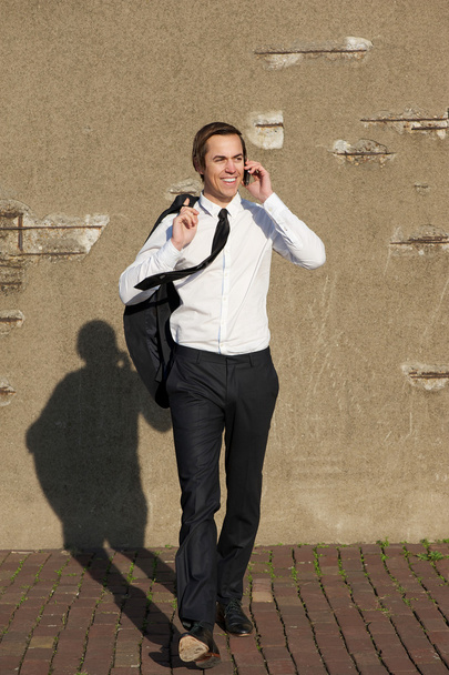 příležitostné podnikatel chodí a mluví na telefonu venku - Fotografie, Obrázek