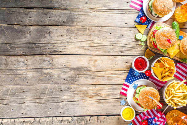 Vier Onafhankelijkheidsdag, 4 juli. Traditionele Amerikaanse Memorial Day Patriottische picknick met hamburgers, frietjes en snacks, Summer USA picknick en bbq concept, Oude houten achtergrond  - Foto, afbeelding