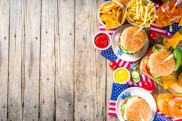Itsenäisyyspäivän kunniaksi, 4. heinäkuuta. Perinteinen American Memorial Day isänmaallinen piknik hampurilaisilla, ranskalaisilla perunoilla ja välipaloilla, Summer USA piknik ja bbq konsepti, vanha puinen tausta
  - Valokuva, kuva