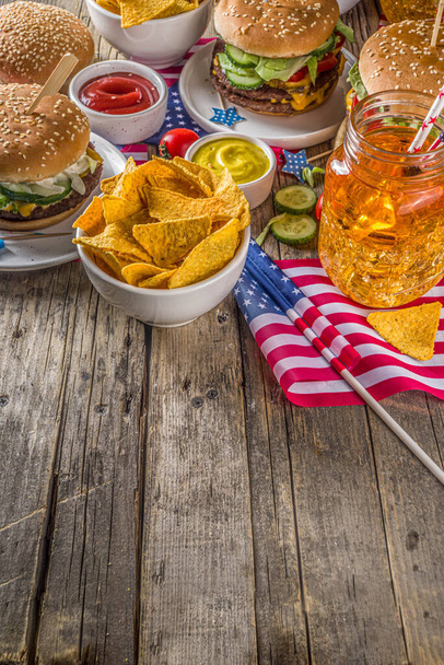 Itsenäisyyspäivän kunniaksi, 4. heinäkuuta. Perinteinen American Memorial Day isänmaallinen piknik hampurilaisilla, ranskalaisilla perunoilla ja välipaloilla, Summer USA piknik ja bbq konsepti, vanha puinen tausta
  - Valokuva, kuva