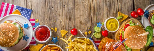 独立記念日、 7月4日。伝統的なアメリカの記念の日ハンバーガーと愛国的なピクニック,フライドポテトと軽食,夏のアメリカのピクニックとbbqの概念,古い木製の背景  - 写真・画像