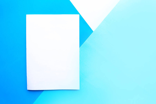 幾何学的な青の背景に白いモックアップブランク。テキストのスペースをコピーします。デザインコンセプト - 写真・画像