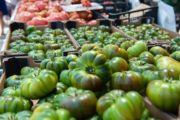 Fresh raw green and pink tomatoes sold on outdoor market. Farm seasonal spanish fruits and vegetables - Foto, Bild