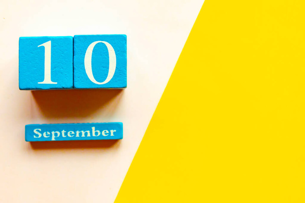 September 10, empty yellow and white geometric background. Wooden handmade calendar - Photo, Image