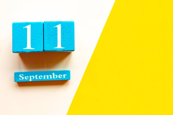 September 11, empty yellow and white geometric background. Wooden handmade calendar - Photo, Image
