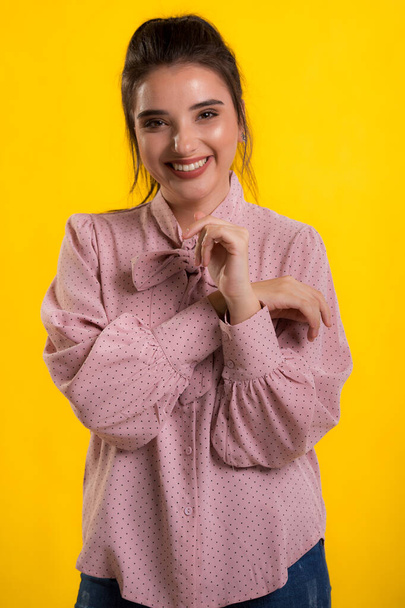 joven hermosa modelo morena en suéter rosa, fondo azul en la espalda, caricias se ve muy dulce cámara, posando en el estudio
, - Foto, imagen
