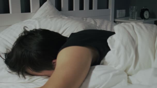 close-up van jonge aziatische man liggen en slapen in het bed thuis. - Video