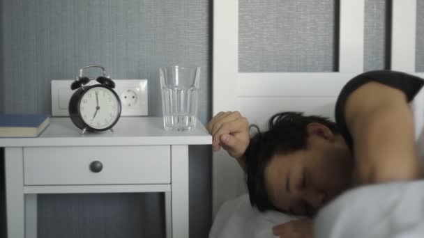 Thirsty man waking up and drinking water in bed at home - Footage, Video