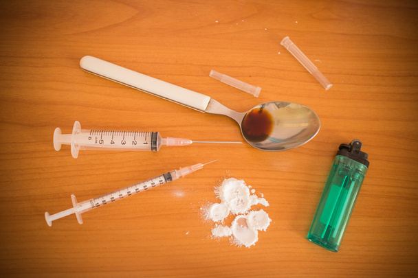 ヘロインの注射器とスプーンと人間のライター - 写真・画像