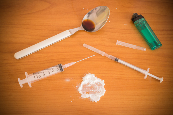 Jeringa y cuchara de heroína y encendedores humanos
 - Foto, Imagen