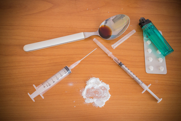 Jeringa y cuchara de heroína y encendedores humanos
 - Foto, imagen